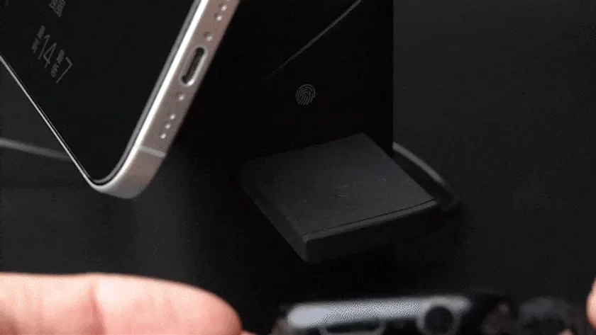 スマートフォンが黒い充電スタンドに立てかけられている