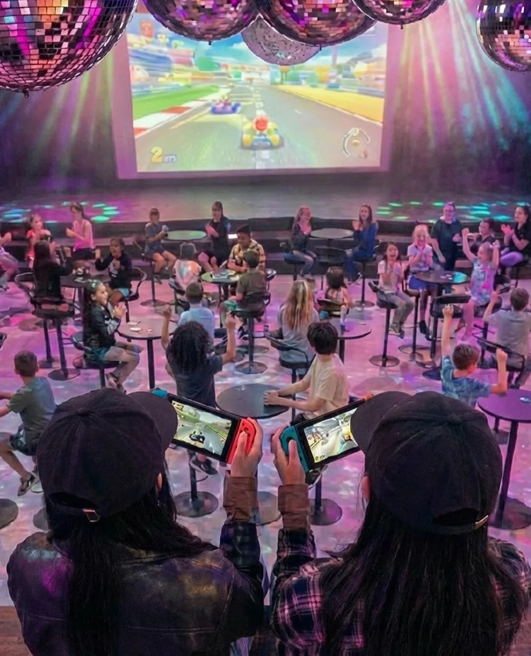 ディスコボールのある会場でゲームを楽しむ子供たち